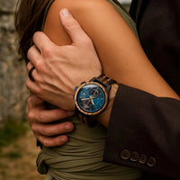 Montre en bois autour d'un bras d'homme, cadran bleu